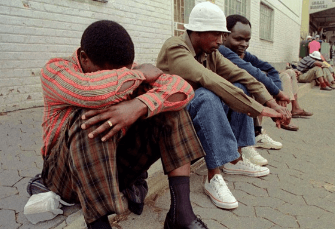 south african Jobless people sitting on pavement